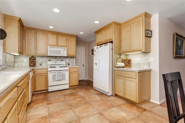 kitchen with light brown cabinets, sink, white appliances, backsplash, and tile counters