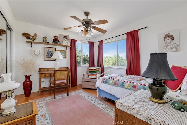 bedroom with a closet, light hardwood / wood-style floors, and ceiling fan