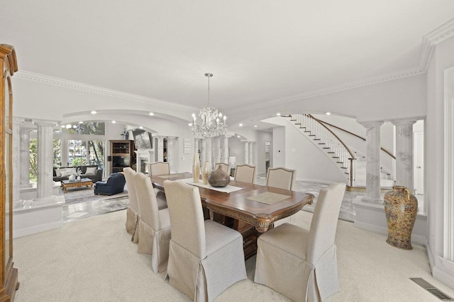 dining room with light carpet, ornamental molding, and a chandelier