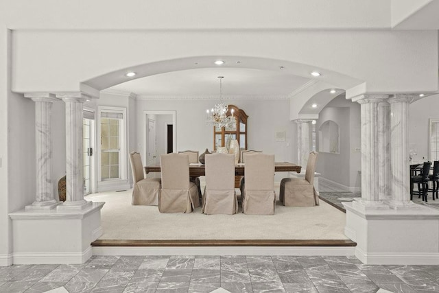 dining room featuring an inviting chandelier, crown molding, and decorative columns