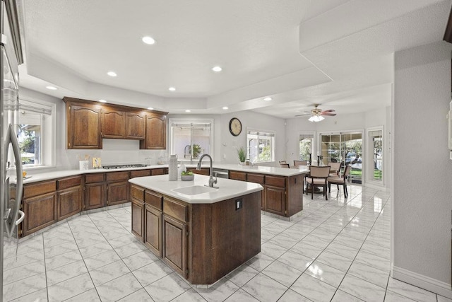 kitchen with a center island with sink, gas cooktop, a healthy amount of sunlight, and ceiling fan