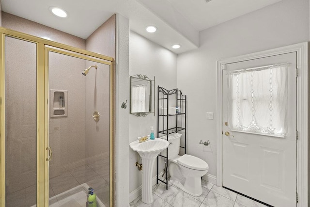 bathroom featuring toilet and a shower with door