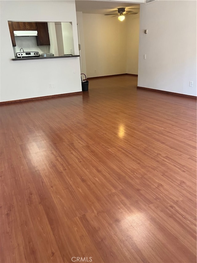 unfurnished living room with ceiling fan, hardwood / wood-style flooring, and sink