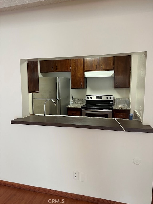 kitchen with dark brown cabinetry, hardwood / wood-style floors, and stainless steel appliances