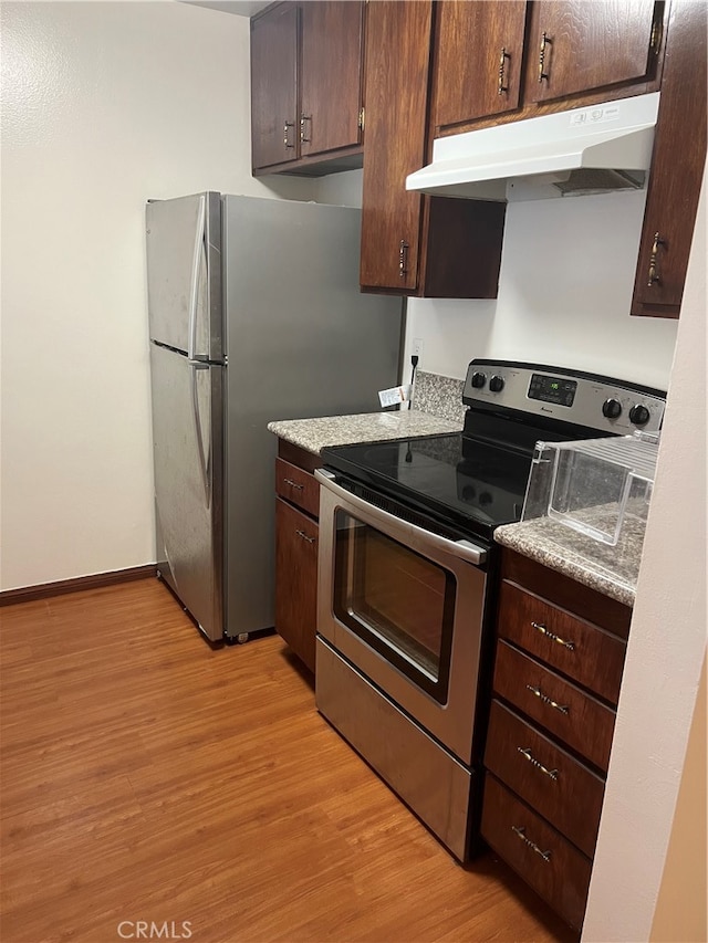 kitchen featuring light wood-type flooring, appliances with stainless steel finishes, and dark brown cabinetry