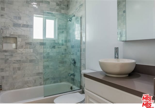 full bathroom with shower / bath combination with glass door, vanity, and toilet