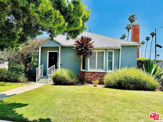 bungalow-style home with a front lawn