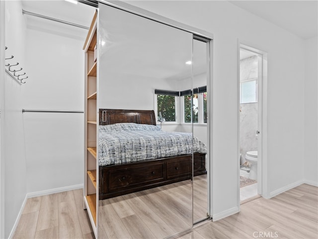 bedroom featuring ensuite bathroom and light hardwood / wood-style flooring