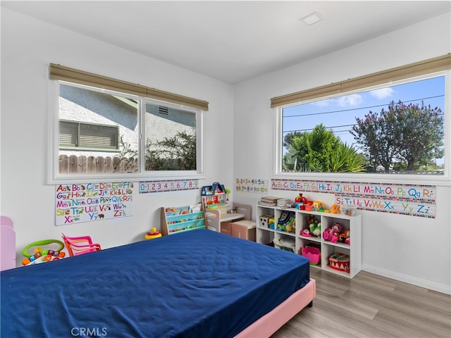 bedroom featuring multiple windows and hardwood / wood-style floors