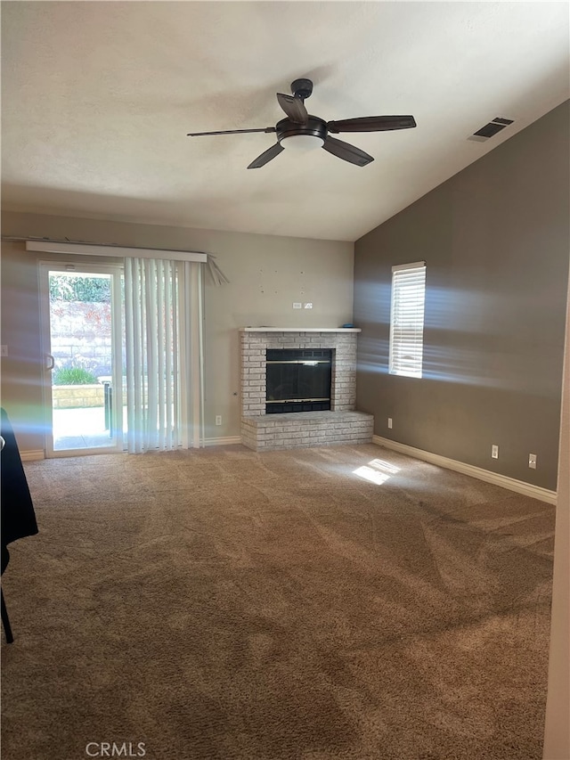 unfurnished living room with carpet floors, a fireplace, vaulted ceiling, and ceiling fan