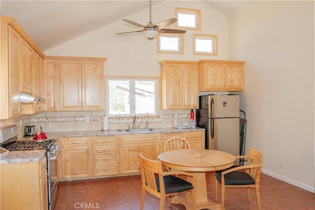 kitchen with tile patterned floors, sink, appliances with stainless steel finishes, light stone countertops, and decorative backsplash