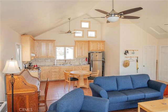 tiled living room featuring ceiling fan, high vaulted ceiling, and sink