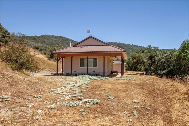 back of house with covered porch and a mountain view