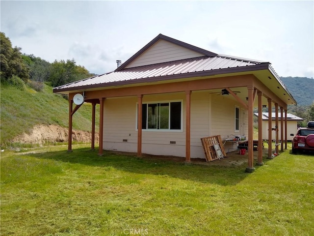 rear view of house with a lawn and ceiling fan