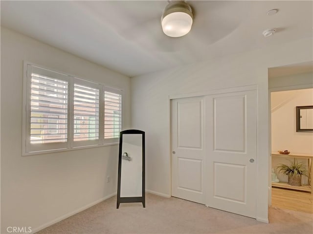 bedroom featuring ceiling fan, a closet, and light carpet