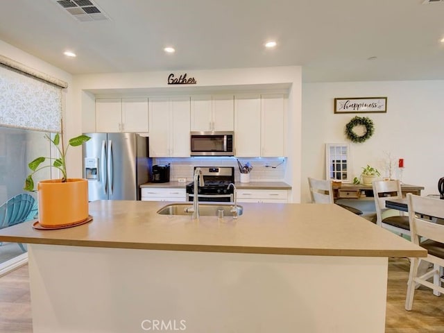 kitchen featuring white cabinets, appliances with stainless steel finishes, and a spacious island