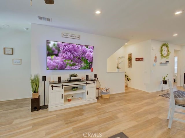 living room with light hardwood / wood-style floors and ceiling fan