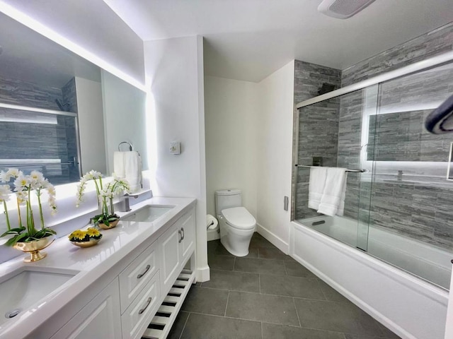 full bathroom featuring vanity, tile patterned flooring, toilet, and combined bath / shower with glass door