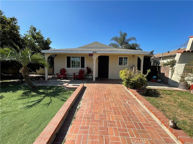 ranch-style house featuring a patio and a front lawn