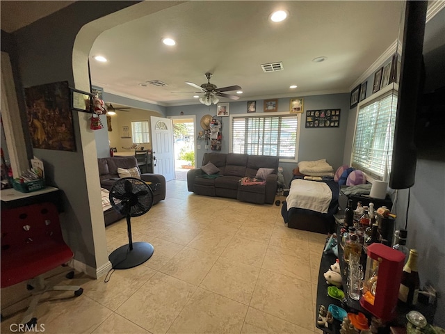 tiled living room with ceiling fan, ornamental molding, and a healthy amount of sunlight