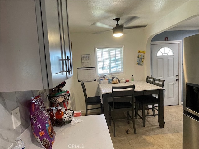 tiled dining area with ceiling fan