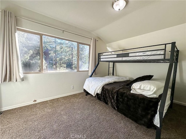 carpeted bedroom featuring lofted ceiling and baseboards