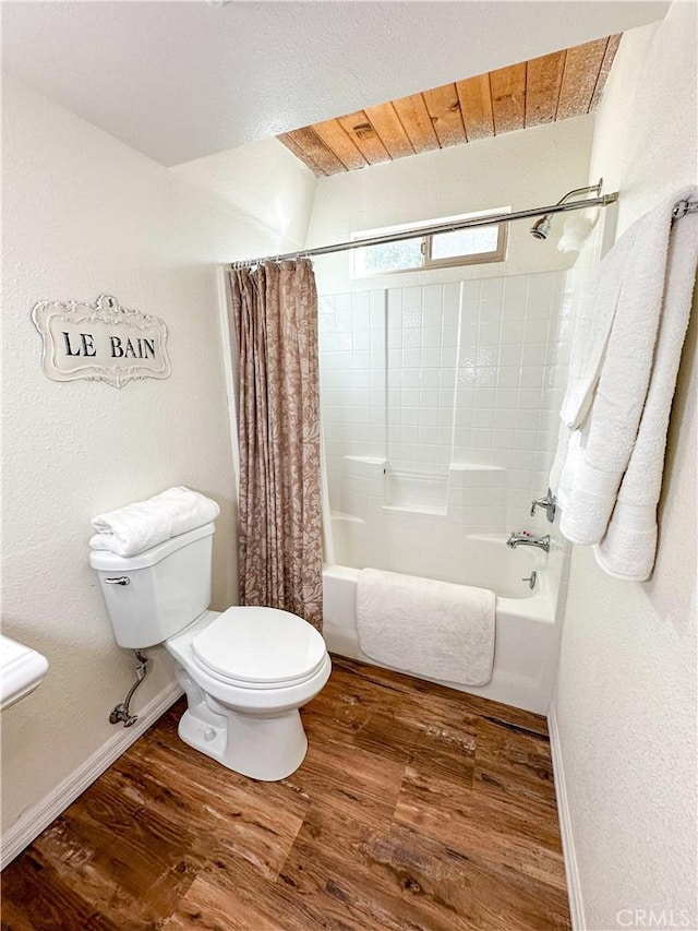 full bath with baseboards, toilet, wood finished floors, and shower / bath combination with curtain