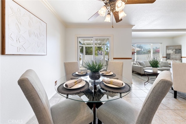 tiled dining space featuring ornamental molding, ceiling fan, and a textured ceiling