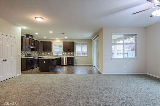 kitchen featuring dark brown cabinetry, sink, hanging light fixtures, a kitchen island, and stainless steel appliances