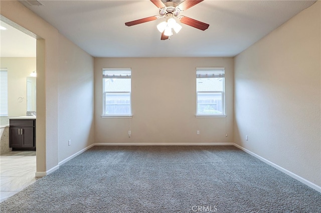 carpeted spare room with ceiling fan