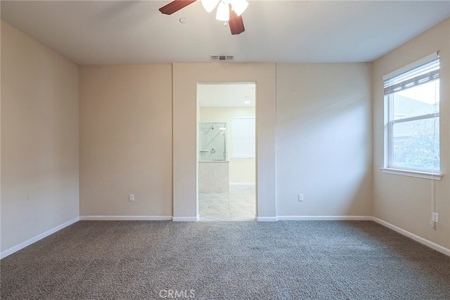 spare room with ceiling fan and carpet