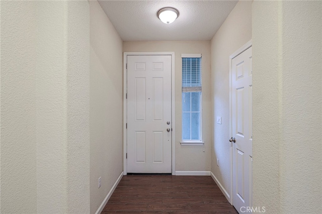 doorway to outside with dark hardwood / wood-style floors and a textured ceiling