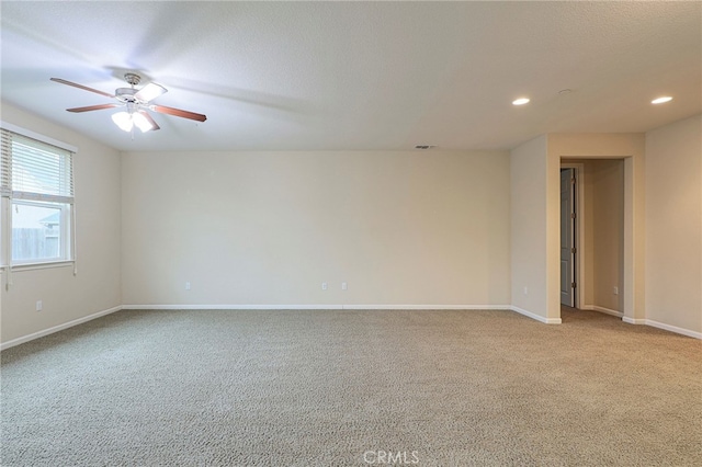 carpeted spare room featuring ceiling fan