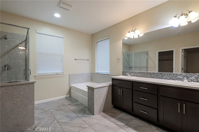 bathroom with tasteful backsplash, vanity, and separate shower and tub