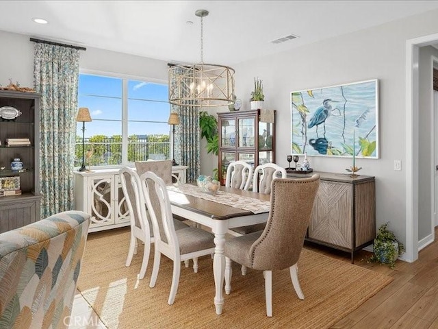 dining area with a notable chandelier and light wood-type flooring