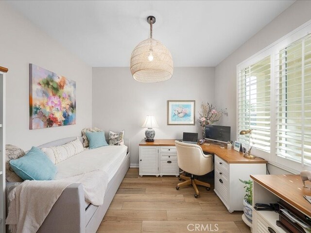 home office with light hardwood / wood-style floors