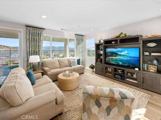 living room featuring a wealth of natural light and light hardwood / wood-style flooring