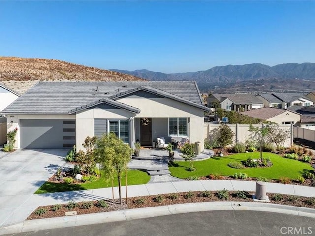 view of front of property featuring a garage, a mountain view, and a front lawn