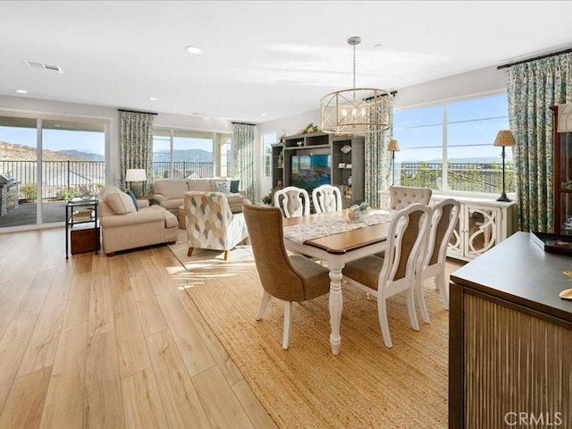 dining space featuring an inviting chandelier and light hardwood / wood-style flooring