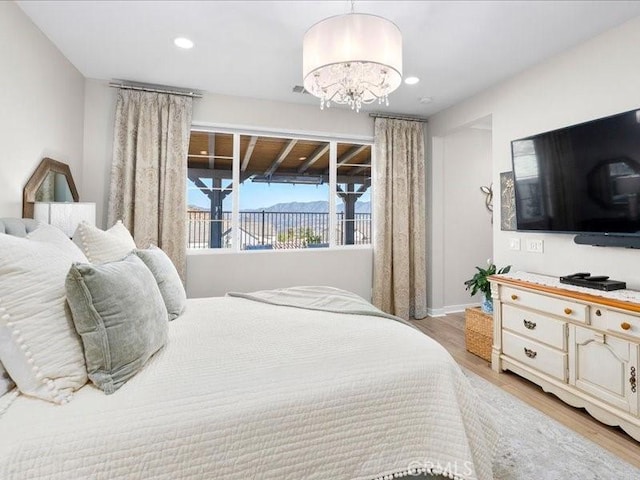 bedroom with an inviting chandelier and light wood-type flooring