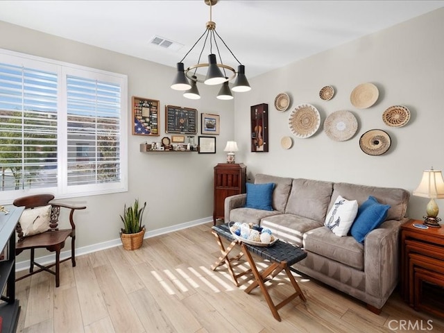 living room featuring a chandelier and light hardwood / wood-style floors