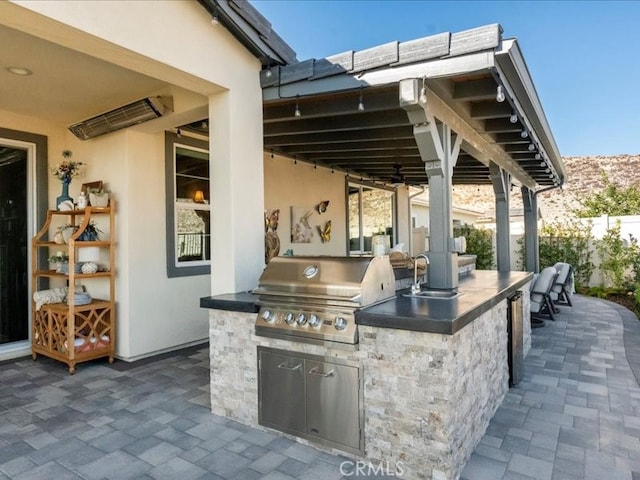 view of patio / terrace with area for grilling, a wet bar, and exterior kitchen