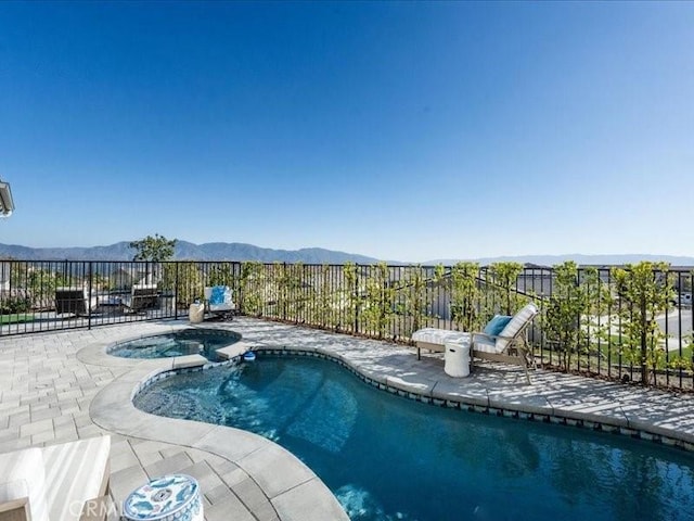 view of swimming pool with an in ground hot tub, a mountain view, and a patio