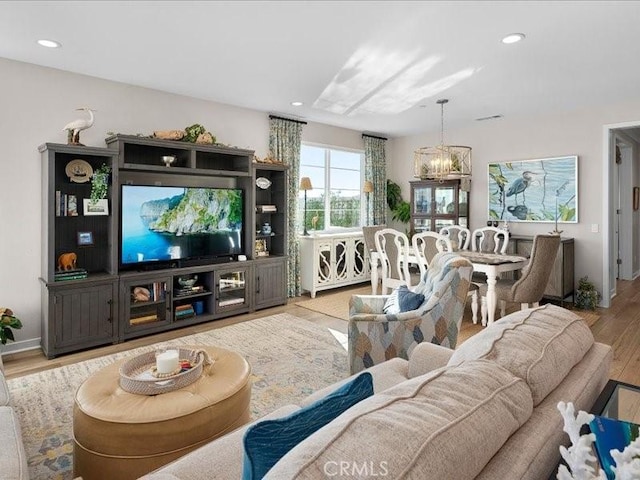 living room featuring a chandelier and light hardwood / wood-style floors