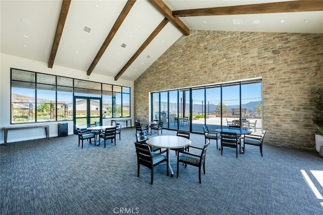 interior space featuring beam ceiling, a mountain view, high vaulted ceiling, and dark carpet