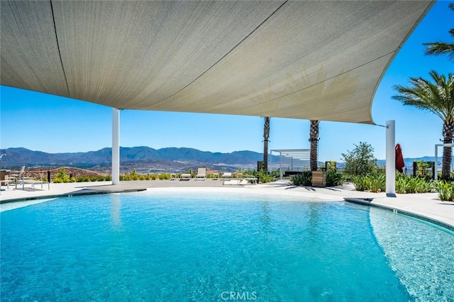 view of swimming pool with a mountain view and a patio area