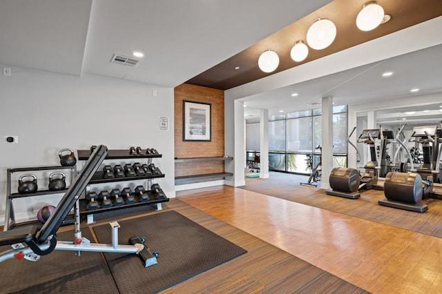 exercise room featuring floor to ceiling windows and hardwood / wood-style floors