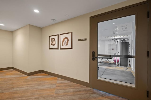 doorway to outside featuring light colored carpet