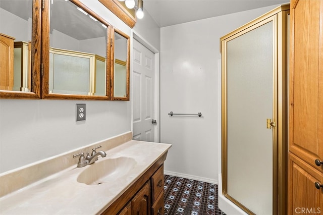 bathroom featuring vanity, a shower with shower door, and tile patterned floors