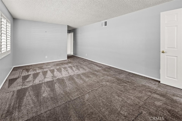 carpeted empty room featuring a textured ceiling